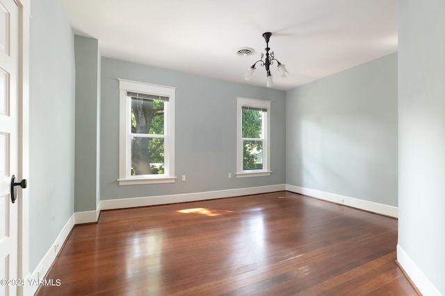 unfurnished room featuring baseboards, visible vents, and dark wood-style flooring