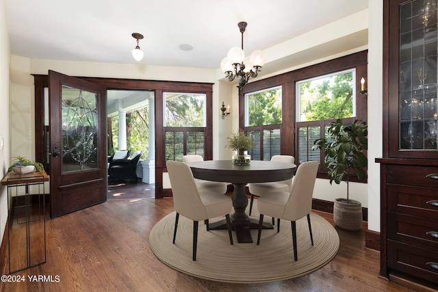 dining space featuring a chandelier, dark wood-style flooring, and baseboards