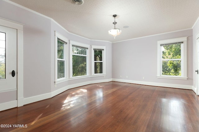 spare room featuring dark wood-style floors, baseboards, visible vents, and crown molding