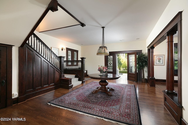 entryway with dark wood-style floors, decorative columns, stairway, and baseboards