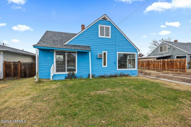 rear view of property with roof with shingles, fence, a chimney, and a lawn