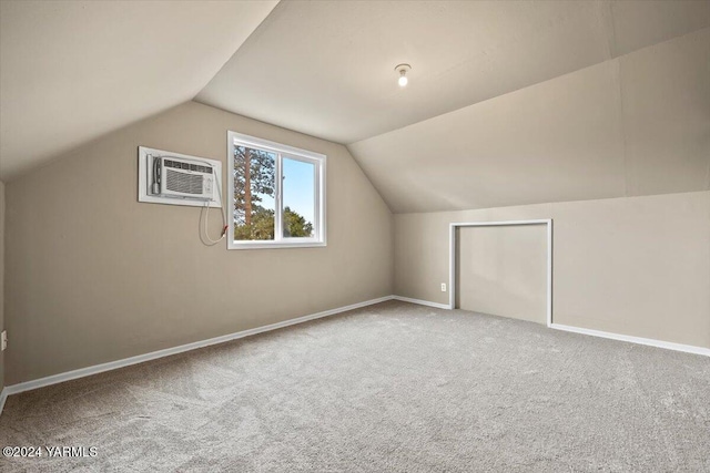 additional living space featuring carpet, baseboards, vaulted ceiling, and an AC wall unit