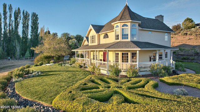 exterior space with covered porch, a chimney, and a lawn