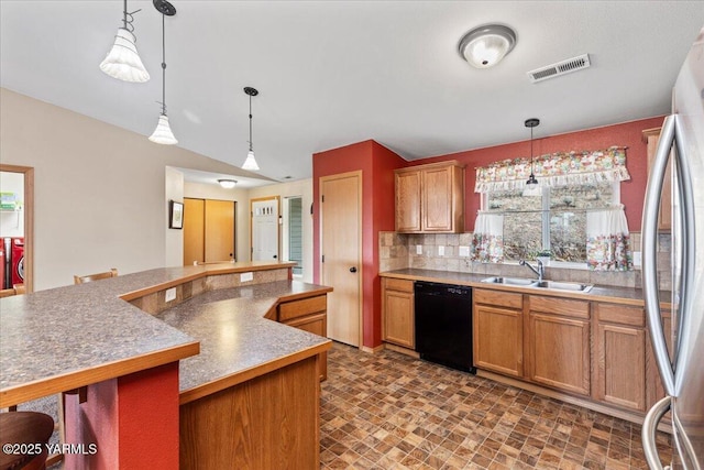 3501 S 40th Ave, Yakima, WA 98903 - kitchen featuring black dishwasher, a sink, backsplash, pendant lighting, and brown cabinets