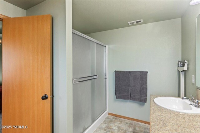 3501 S 40th Ave, Yakima, WA 98903 - bathroom featuring a sink, a stall shower, and baseboards