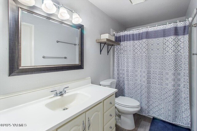 full bathroom featuring toilet, curtained shower, wood finished floors, and vanity