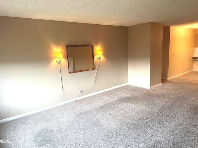 carpeted spare room with baseboards and a textured ceiling