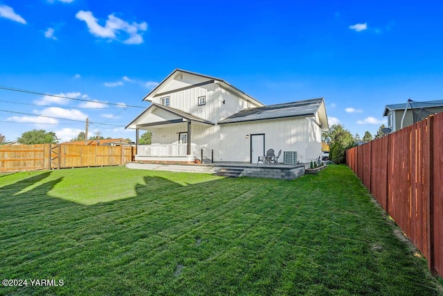 back of house with a yard, a fenced backyard, and a patio