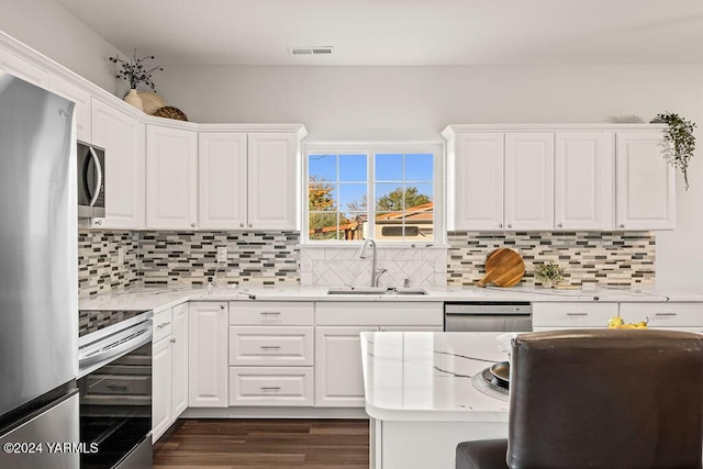 kitchen featuring a sink, visible vents, white cabinetry, appliances with stainless steel finishes, and dark wood finished floors