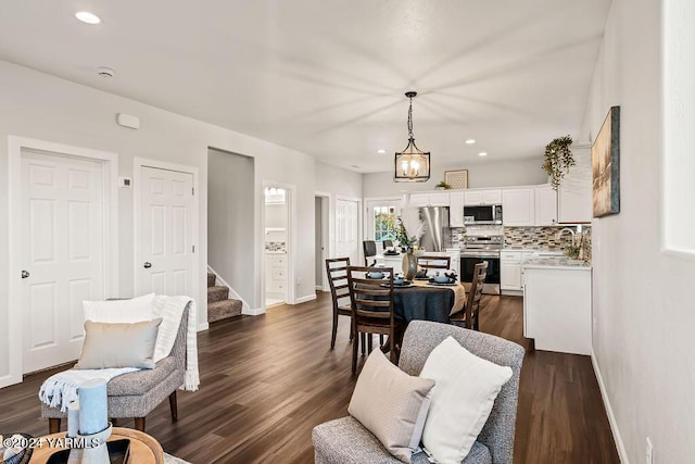 living area featuring dark wood-style flooring, stairway, and baseboards