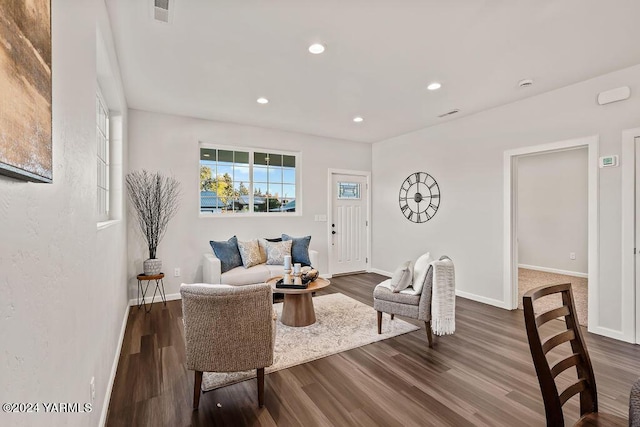 living room with recessed lighting, visible vents, baseboards, and wood finished floors