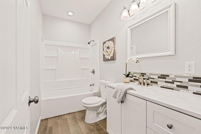 full bathroom featuring backsplash, toilet, tub / shower combination, vanity, and wood finished floors