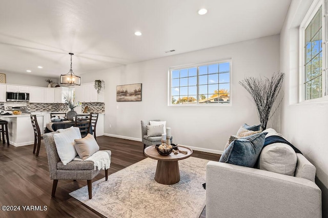 living area featuring baseboards, dark wood finished floors, and recessed lighting