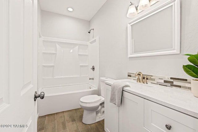 bathroom with tasteful backsplash, toilet, wood finished floors,  shower combination, and vanity