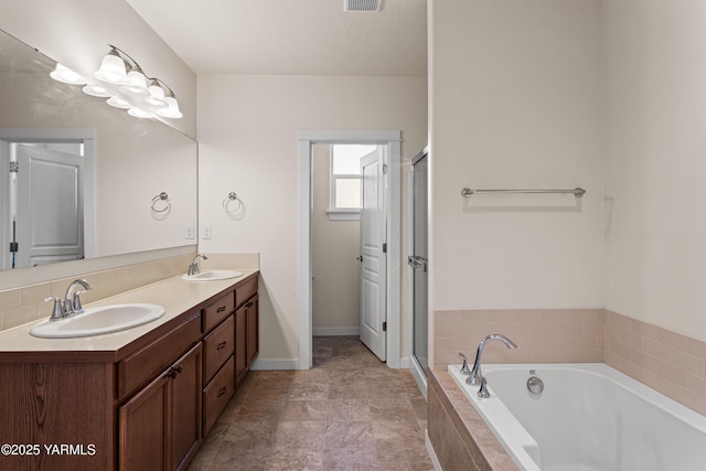 bathroom with a bath, double vanity, a stall shower, and baseboards