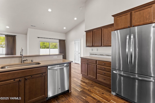 kitchen featuring appliances with stainless steel finishes, a sink, healthy amount of natural light, dark wood-style flooring, and recessed lighting
