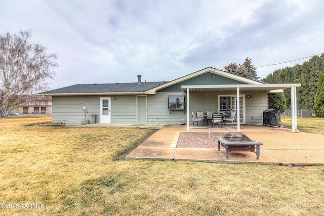 back of property featuring a fire pit, a lawn, a patio area, and fence