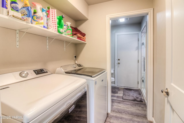 laundry room with laundry area, wood finished floors, and washing machine and dryer