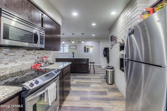 kitchen with stainless steel appliances, recessed lighting, decorative backsplash, dark brown cabinets, and wood finished floors