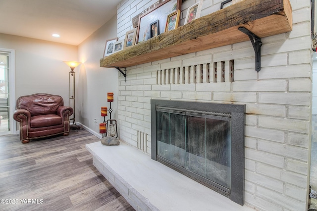 interior details featuring a brick fireplace, baseboards, wood finished floors, and recessed lighting