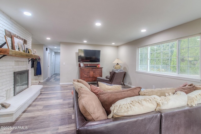 living room with recessed lighting, a fireplace, baseboards, and wood finished floors