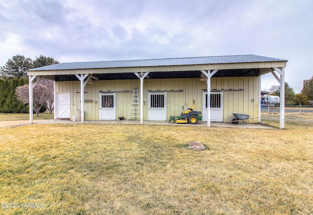 view of front of property with a detached garage, metal roof, an exterior structure, and an outbuilding