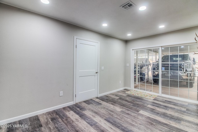 unfurnished room featuring baseboards, visible vents, wood finished floors, and recessed lighting