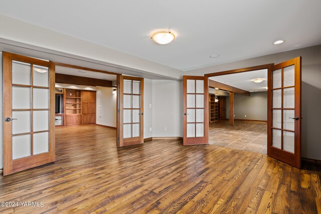 unfurnished room with recessed lighting, baseboards, wood finished floors, and french doors