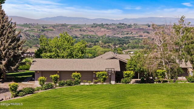 view of front facade with a garage, a front yard, and a mountain view