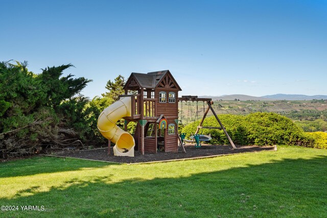 view of jungle gym featuring a yard and a mountain view