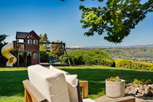 view of jungle gym featuring a mountain view and a lawn