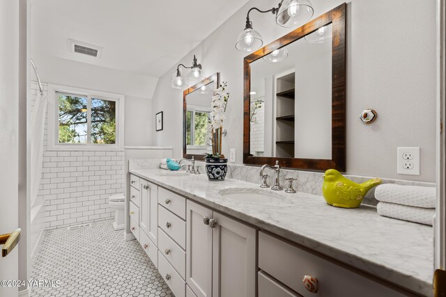 bathroom with double vanity, tile patterned flooring, visible vents, and a sink