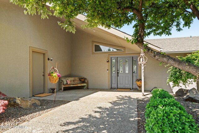 entrance to property featuring stucco siding