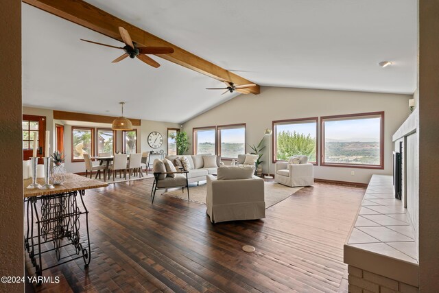 living room featuring a fireplace, vaulted ceiling with beams, baseboards, and wood finished floors