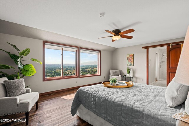 bedroom with vaulted ceiling, wood finished floors, visible vents, and baseboards