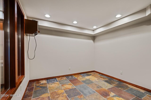 below grade area with baseboards, recessed lighting, and stone tile floors