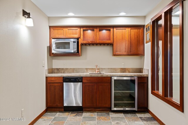 kitchen featuring stainless steel appliances, wine cooler, light countertops, and a sink