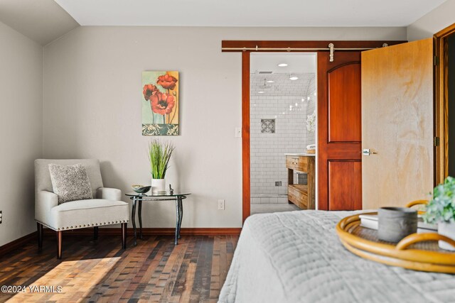 bedroom featuring baseboards, vaulted ceiling, dark wood-style flooring, and ensuite bathroom