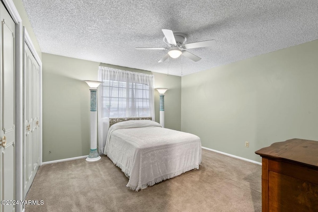 bedroom with light colored carpet, ceiling fan, a textured ceiling, and baseboards