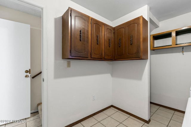 laundry room featuring light tile patterned floors and baseboards