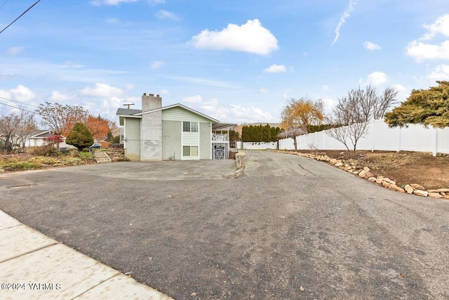 exterior space featuring a chimney and fence