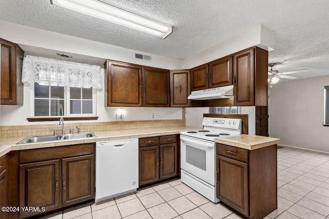 kitchen with white appliances, visible vents, light countertops, under cabinet range hood, and a sink