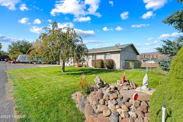 view of front of home with a gate, driveway, a front yard, and fence