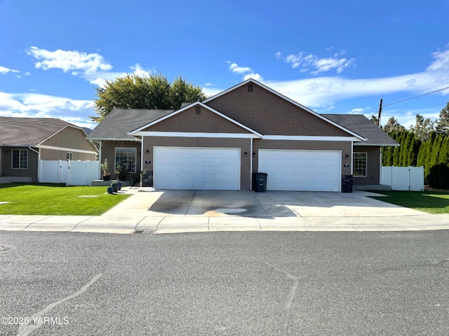 view of front of property featuring concrete driveway, fence, a front lawn, and a garage