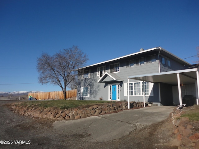 view of front of house with driveway, fence, and a carport