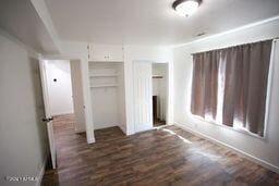 unfurnished bedroom featuring dark wood-style floors