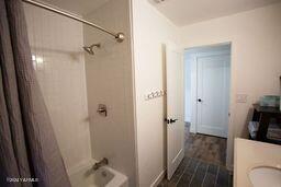 full bath with  shower combination and wood finished floors