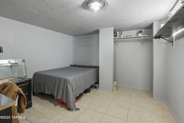 bedroom featuring tile patterned floors, baseboards, and a textured ceiling