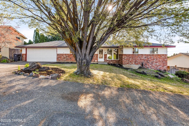 607 N 53rd Ave, Yakima, WA 98908 - view of front of house featuring brick siding, asphalt driveway, and a garage