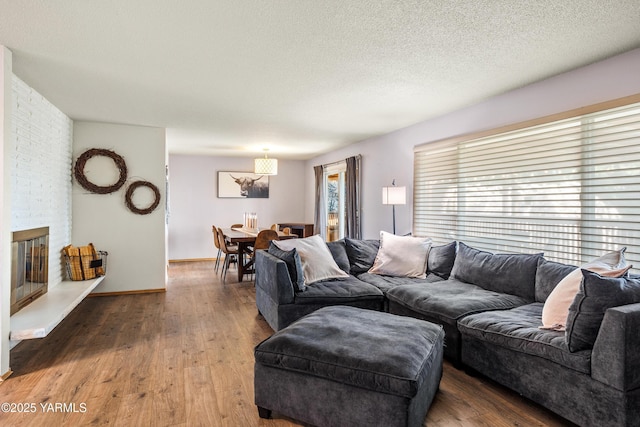 607 N 53rd Ave, Yakima, WA 98908 - living area with wood finished floors, a brick fireplace, and a textured ceiling
